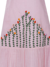 Pink cotton silk midi dress with hand-embroidered floral pattern and tiered hem, close-up view