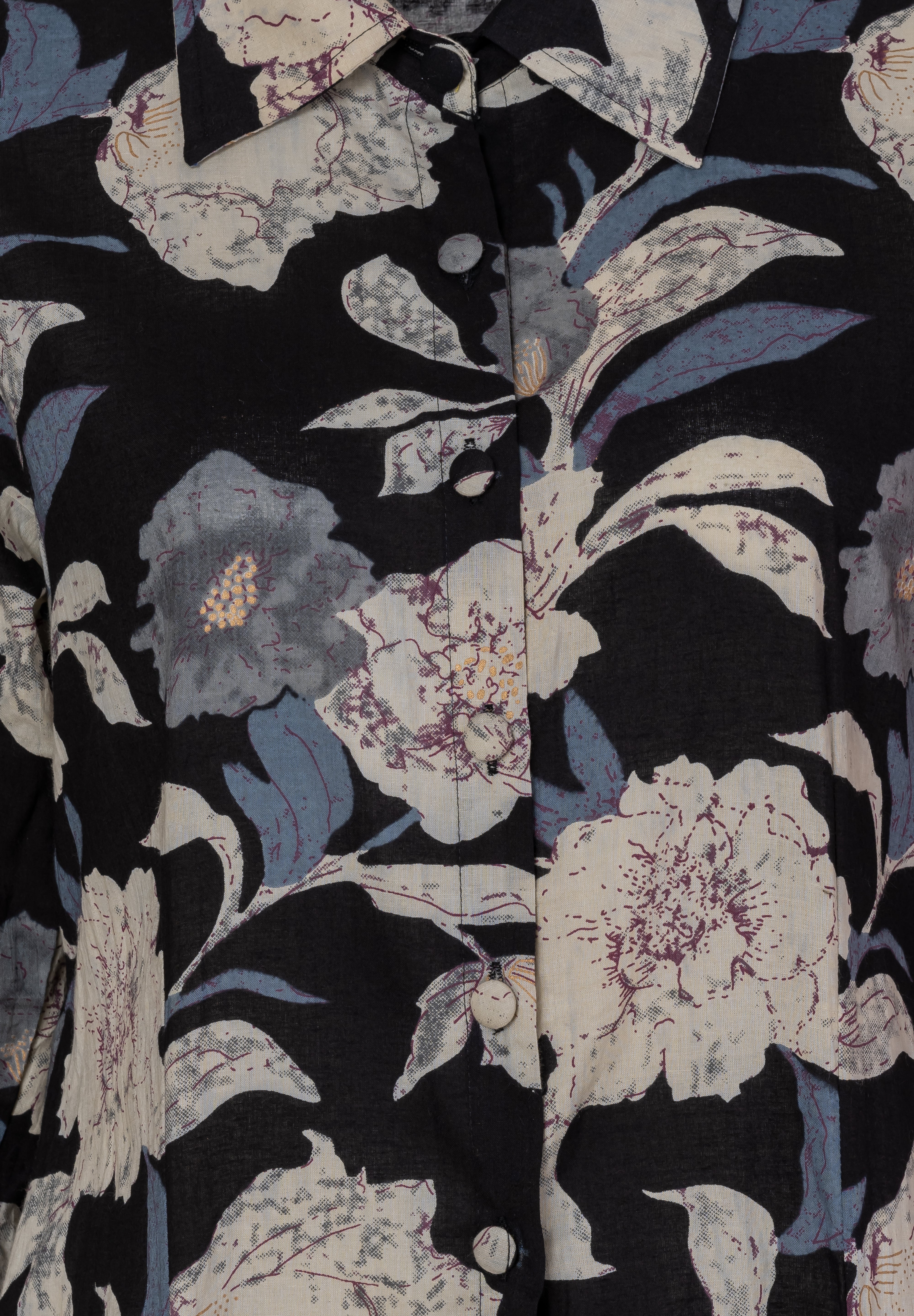 Black cotton shirt dress with bold floral and chevron print, featuring cream, blue, and purple tones, button front, and collar detail, close-up view