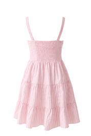 Pink tiered dress with thin straps on a white background