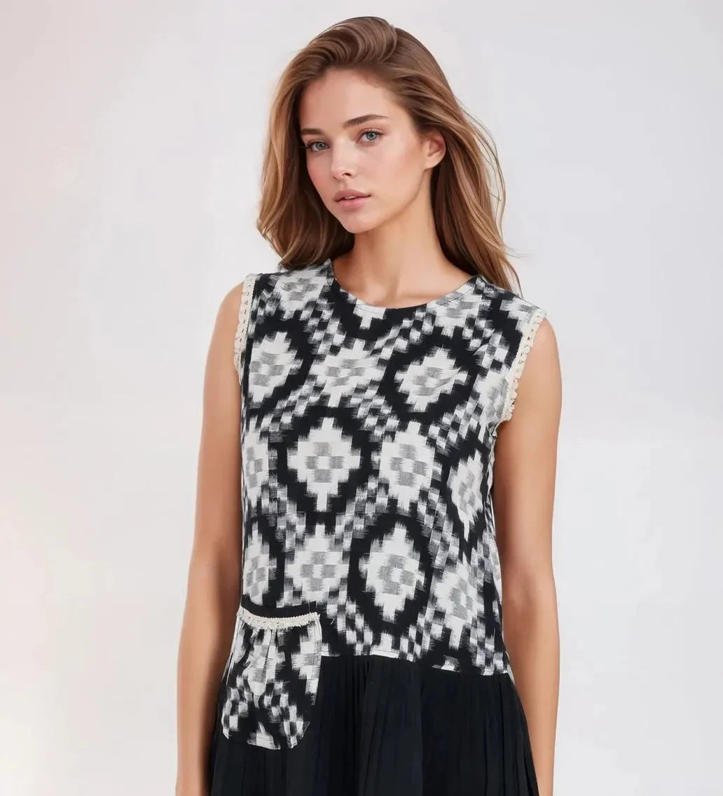 Woman wearing a black and white patterned sleeveless dress on a white background