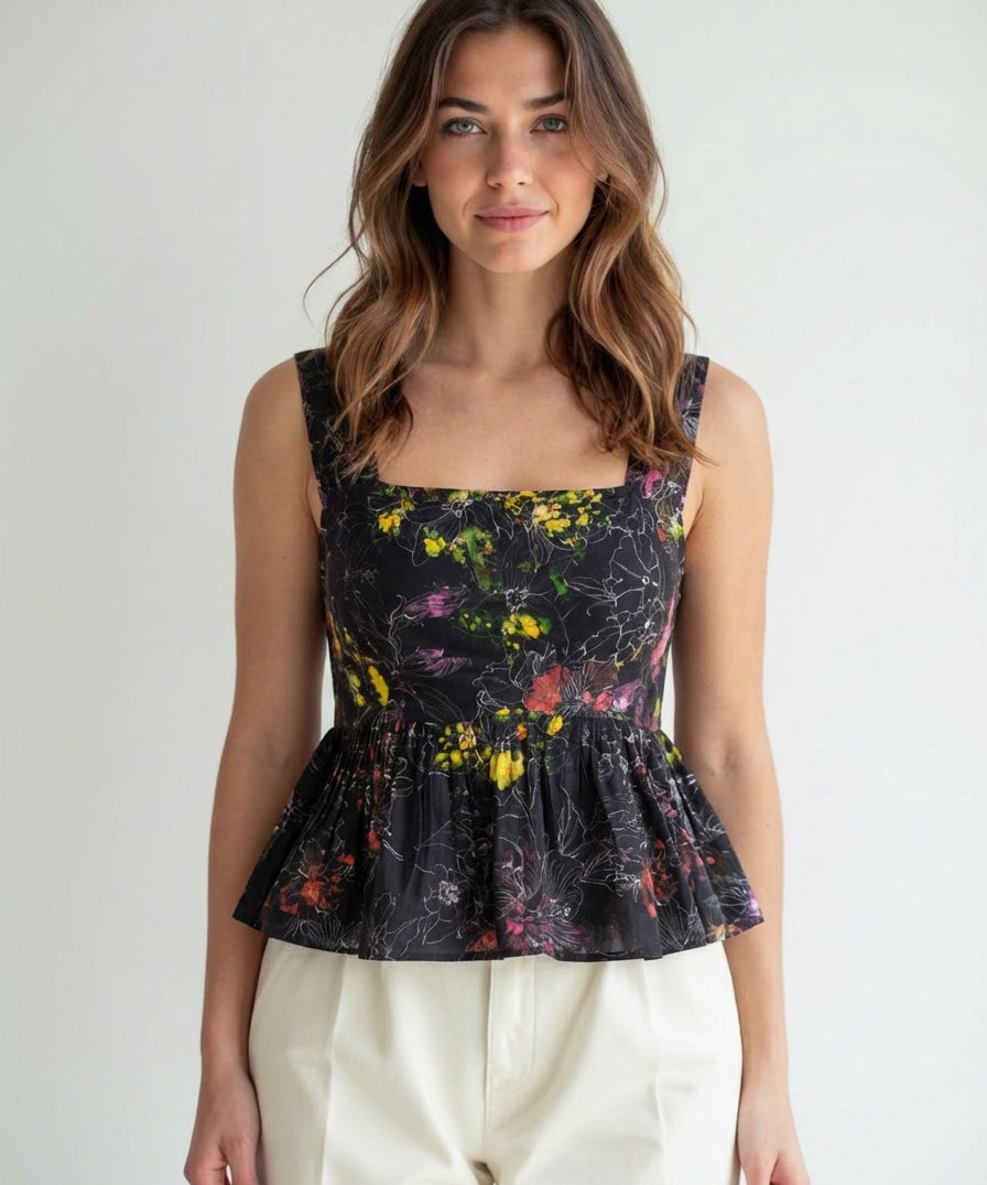 Woman wearing a floral peplum top against a plain background