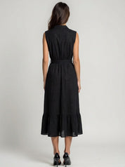 Woman wearing a black sleeveless dress on a plain background