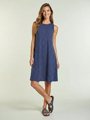 Woman wearing a blue polka dot dress on a light background