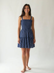 Woman wearing a blue patterned dress against a white background
