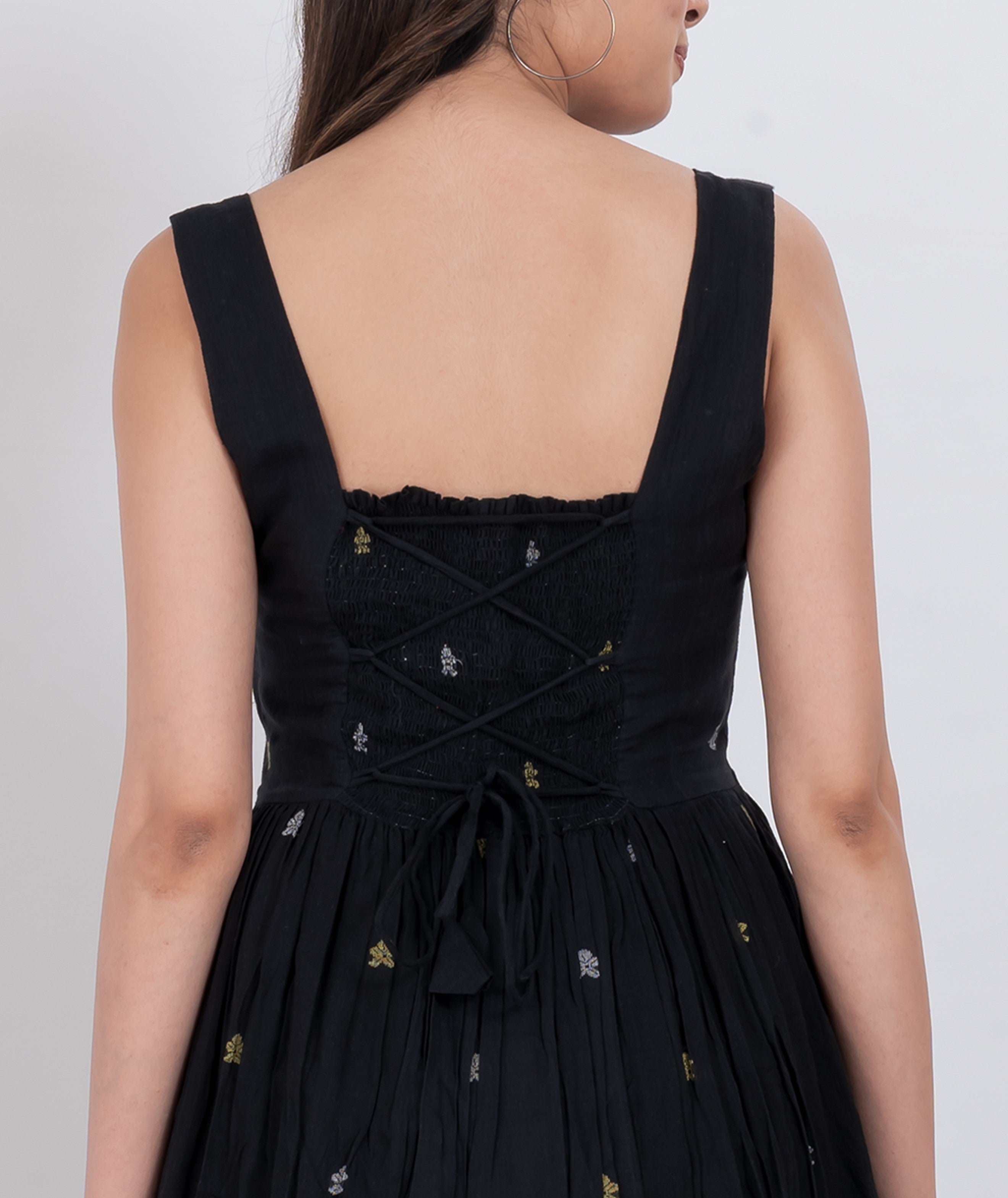  Boho-inspired handwoven cotton floral dress with button closure and sleeveless design.