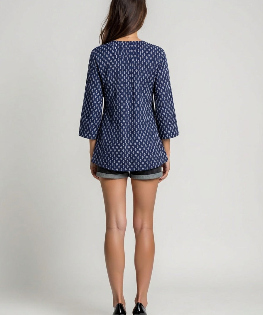 Woman wearing a blue patterned dress on a plain background