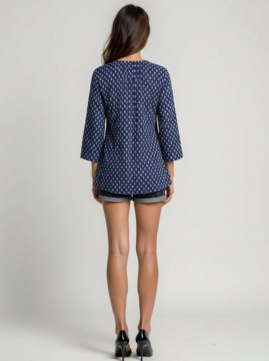 Woman wearing a blue patterned dress on a plain background