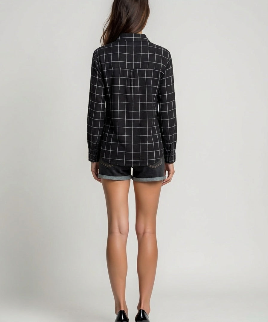 Person wearing a black and white checkered blazer and denim shorts on a plain background
