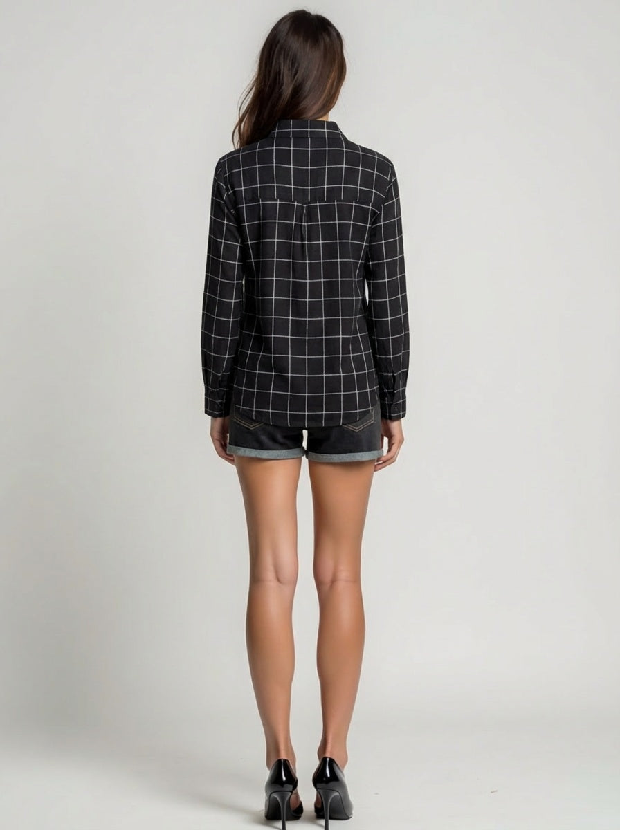 Person wearing a black and white checkered blazer and denim shorts on a plain background