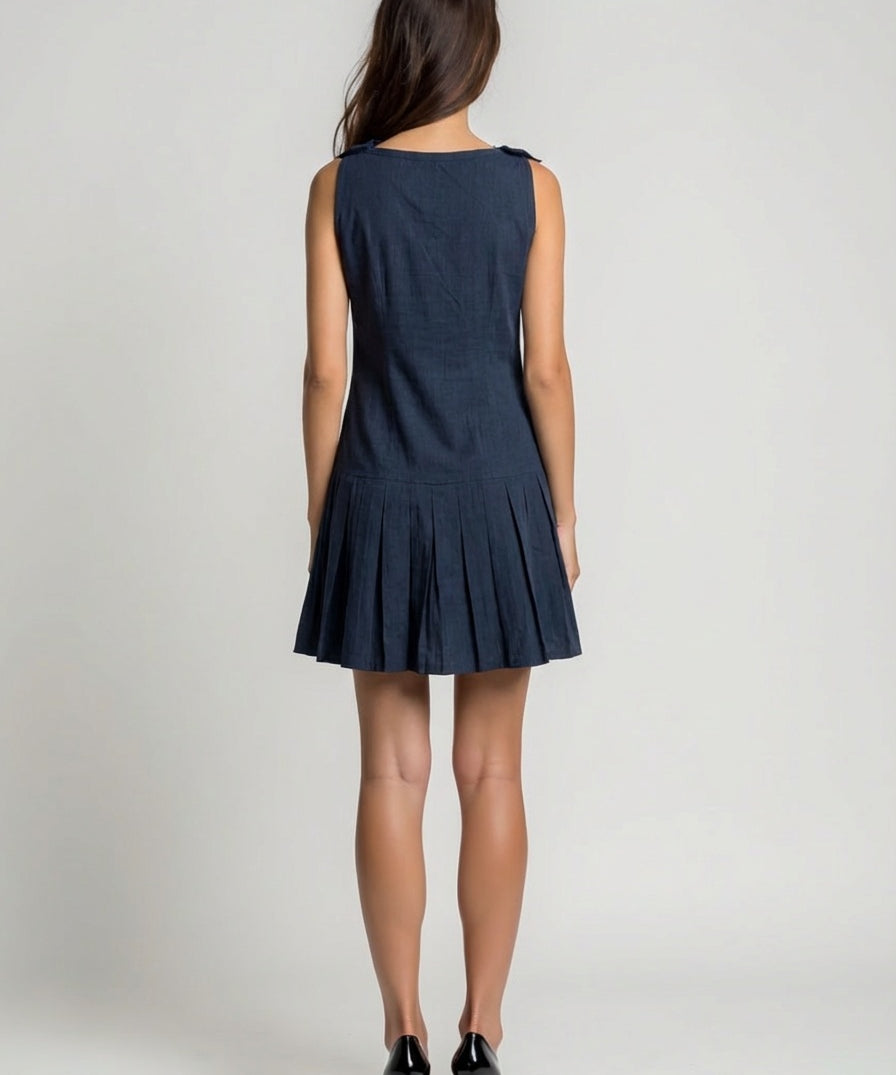 Woman wearing a navy blue dress on a plain background