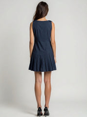 Woman wearing a navy blue dress on a plain background