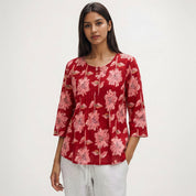 Woman wearing a red floral blouse against a white background