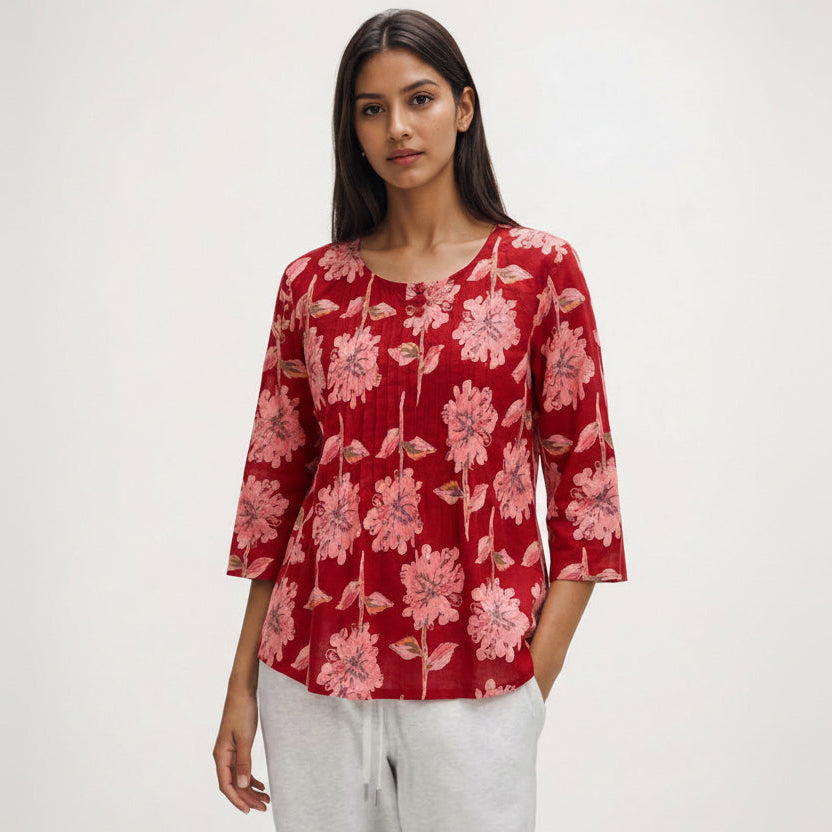 Woman wearing a red floral blouse against a white background