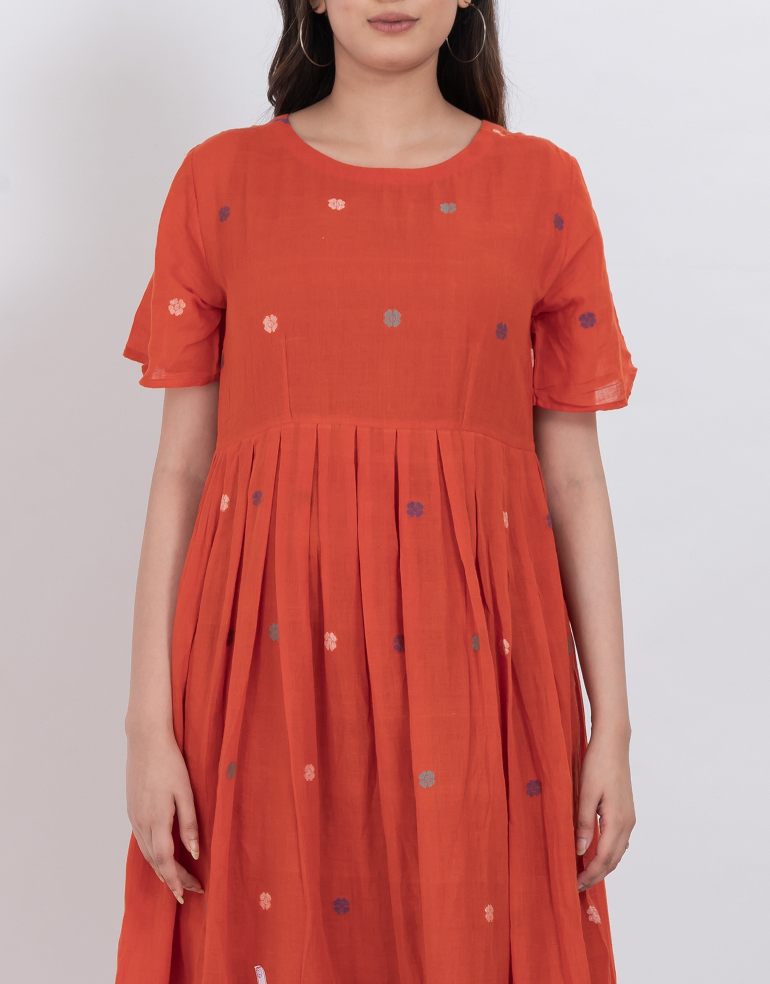  Full view of a floral embroidered handwoven cotton dress with pleated A-line and short sleeves.