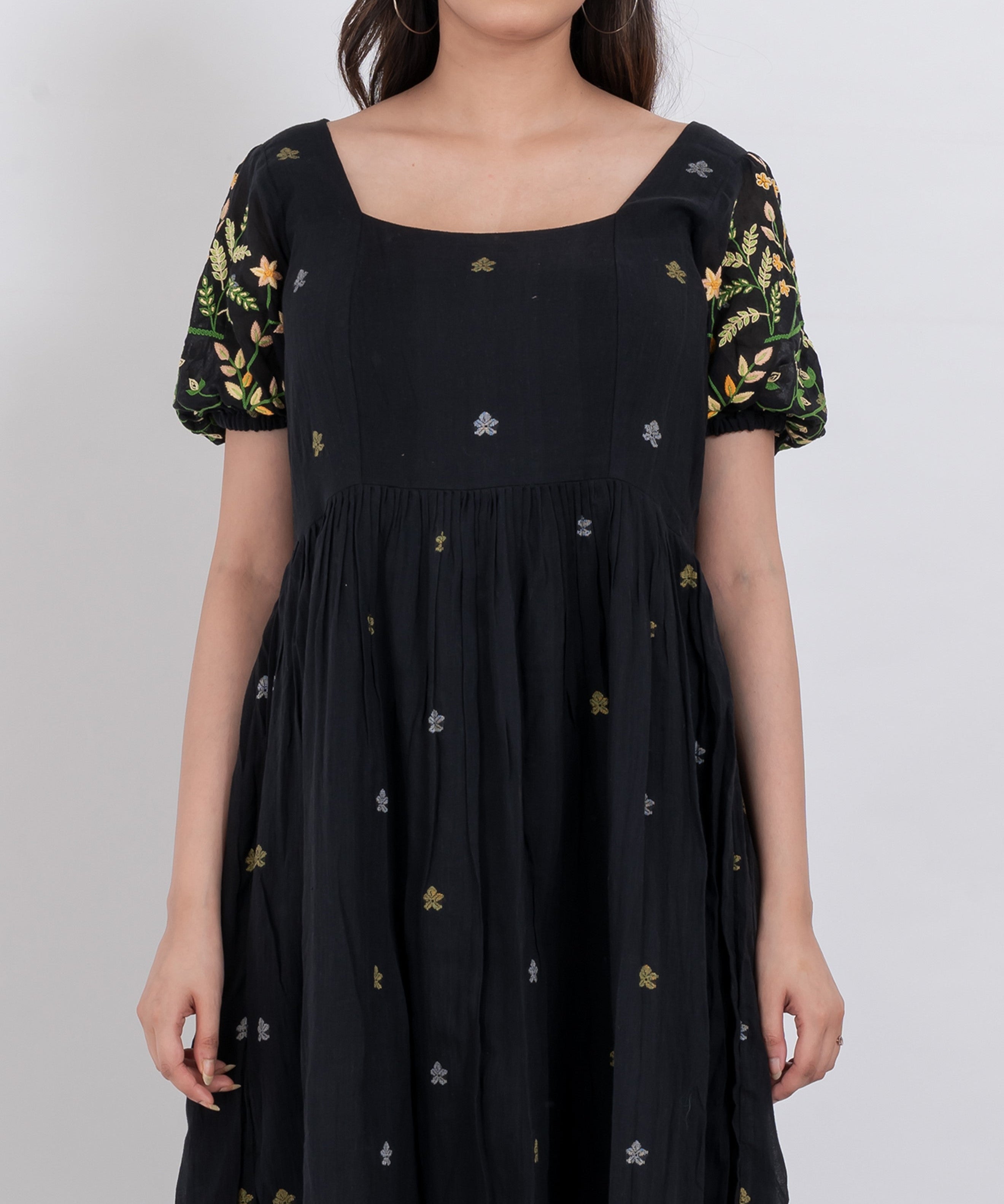 A full-length view of a floral embroidered handwoven cotton dress, perfect for summer outings.