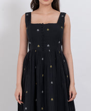  Close-up of button details and floral embroidery on a handwoven cotton dress