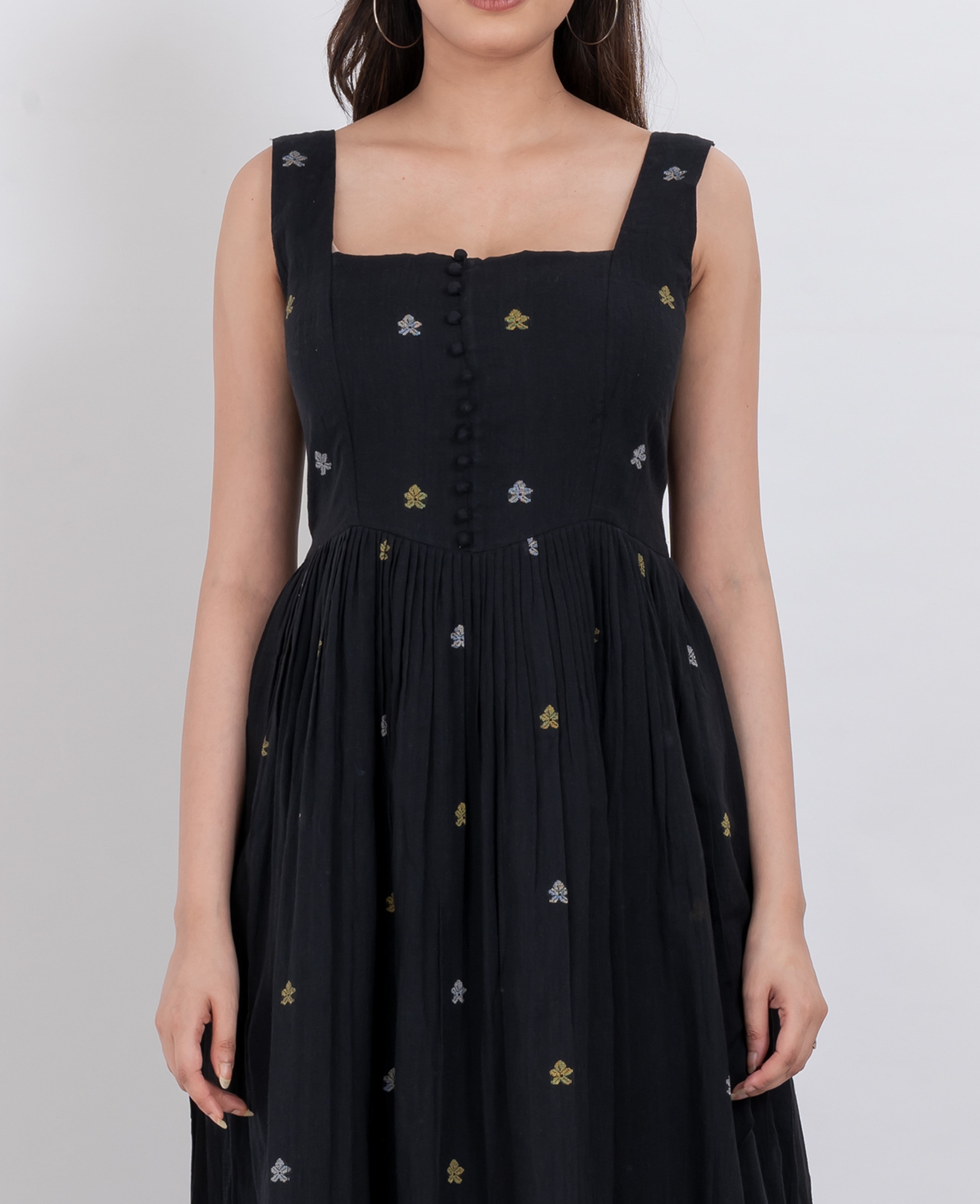  Close-up of button details and floral embroidery on a handwoven cotton dress
