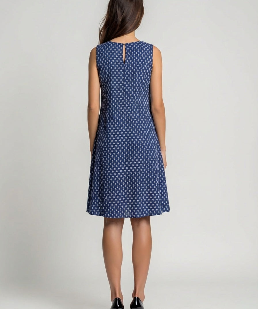 Woman wearing a blue polka dot dress on a plain background