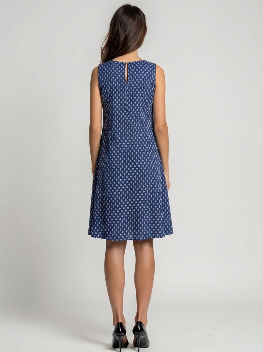 Woman wearing a blue polka dot dress on a plain background