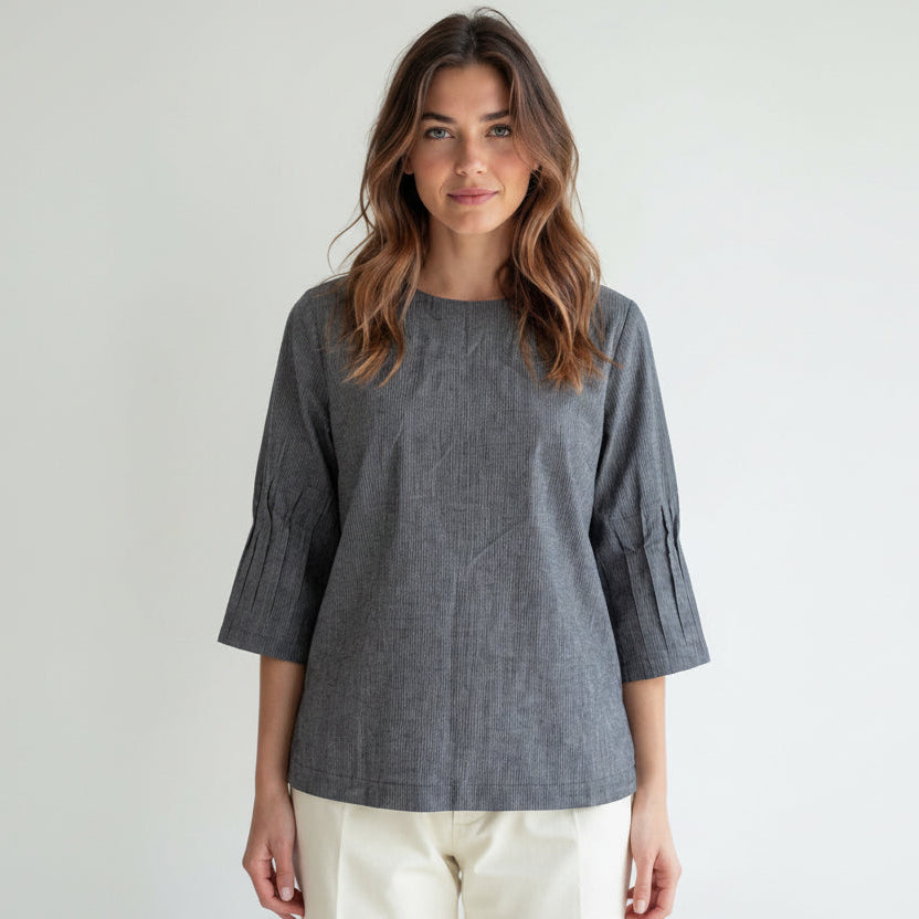Woman wearing a gray blouse with a plain background