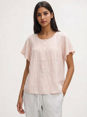 Woman wearing a light pink blouse with short sleeves on a white background
