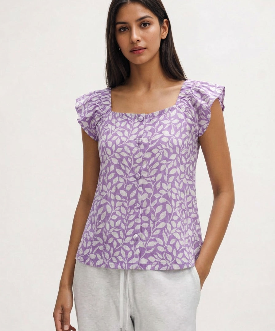 Woman wearing a purple floral top against a white background