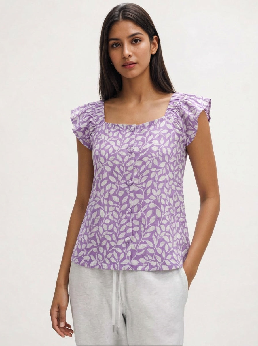 Woman wearing a purple floral top against a white background
