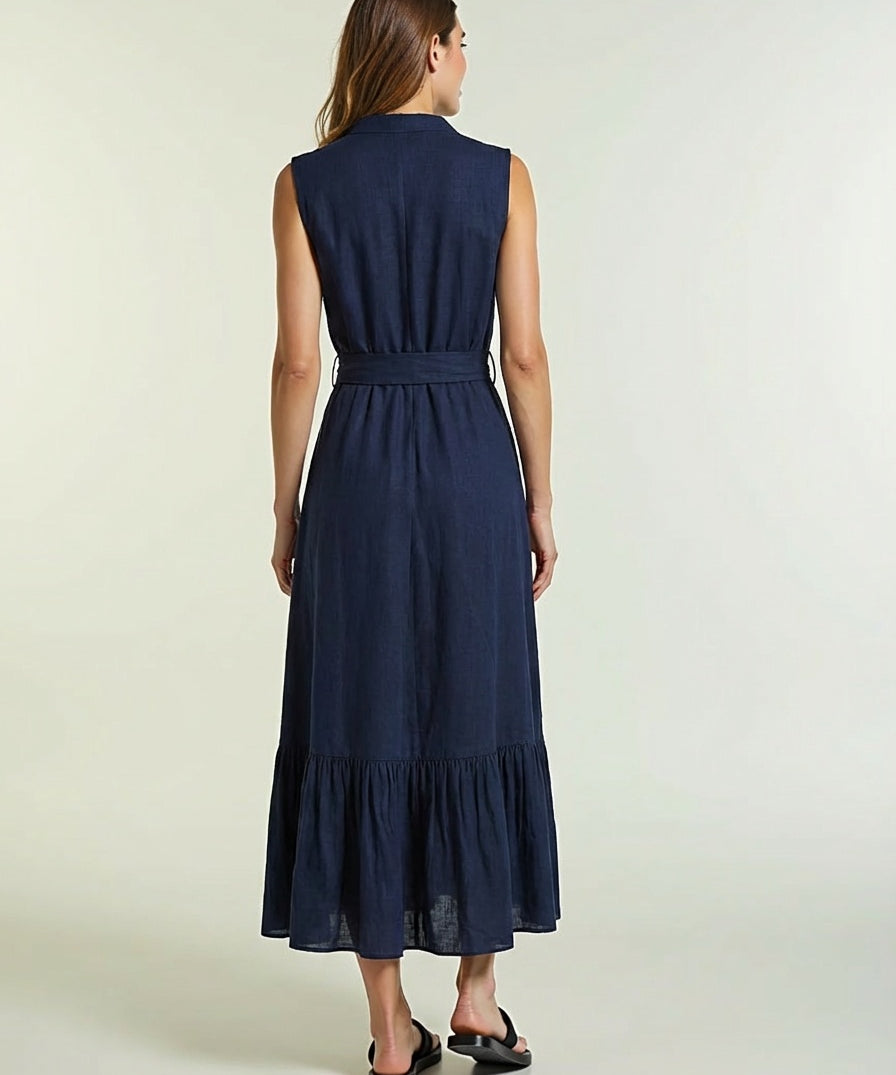 Woman wearing a navy blue dress with a belt on a light background