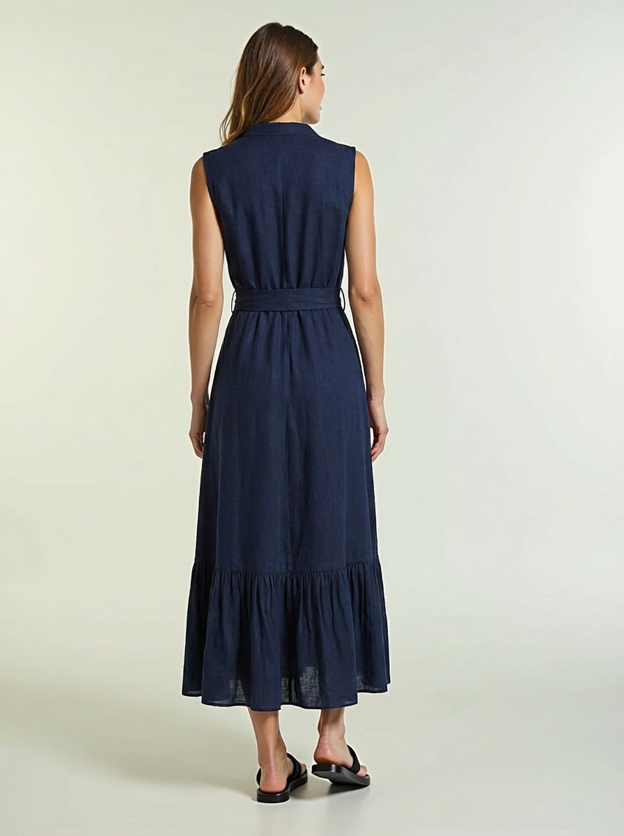 Woman wearing a navy blue dress with a belt on a light background