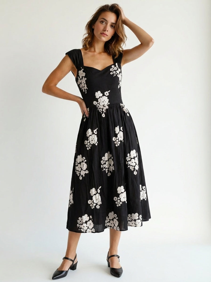 Woman wearing a black dress with white floral patterns party mood forck gown