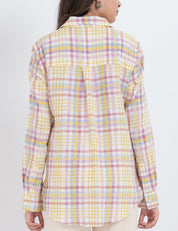 Model wearing a pastel plaid button-up shirt with long sleeves.