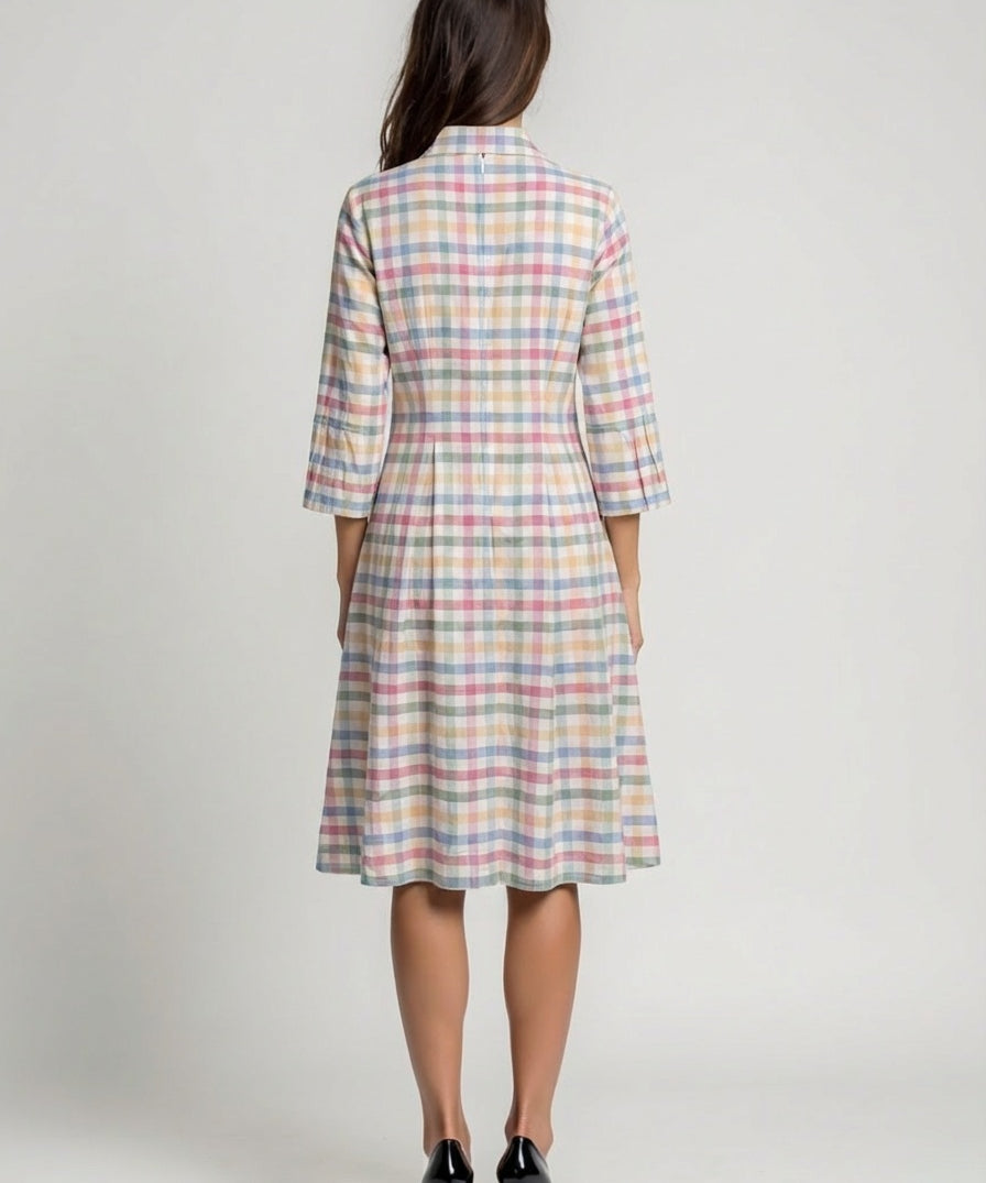 Woman wearing a plaid dress with a neutral background