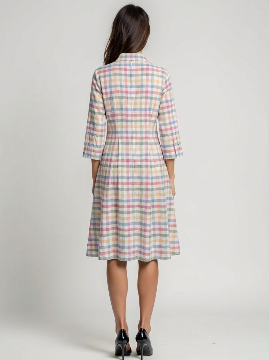 Woman wearing a plaid dress with a neutral background