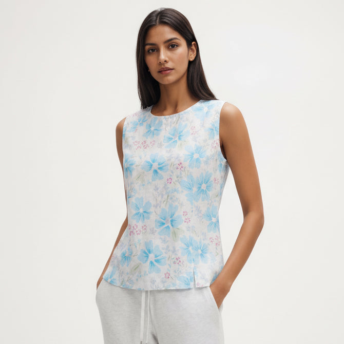 Woman wearing a sleeveless floral top with a white background