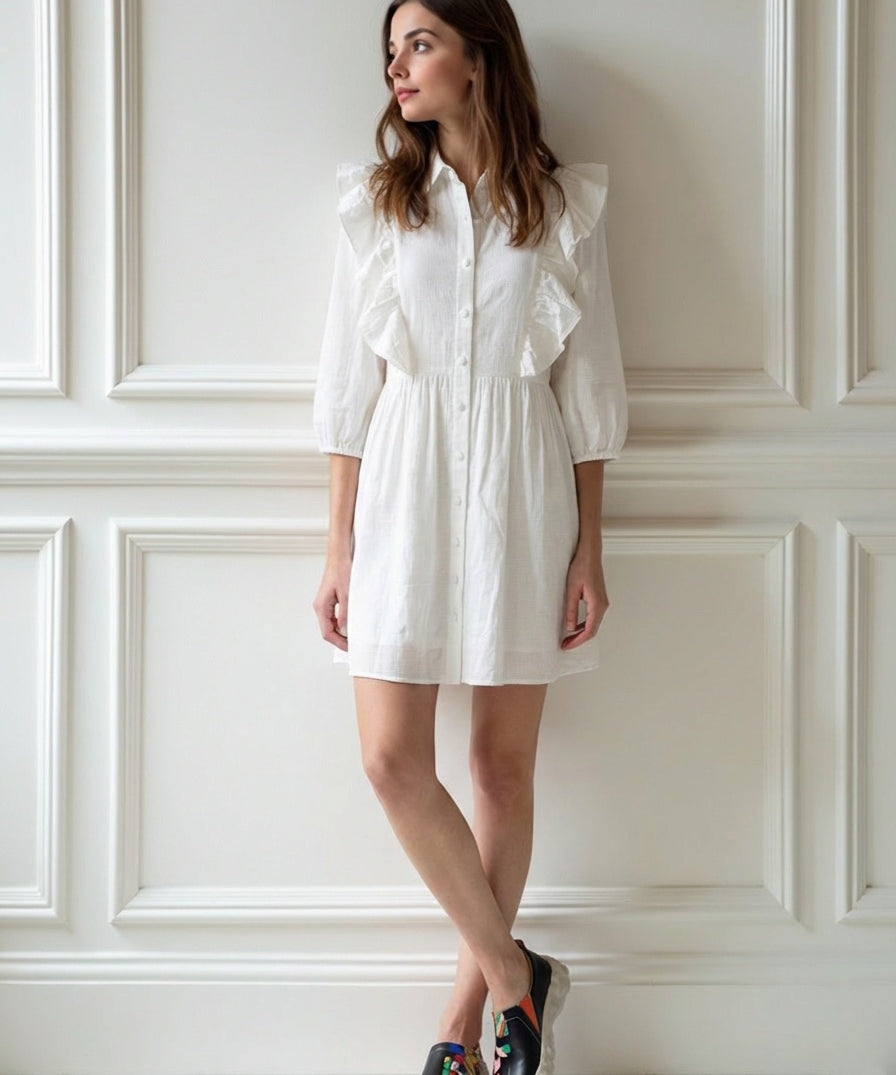Woman wearing a white dress with ruffled sleeves