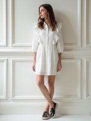 Woman wearing a white dress with ruffled sleeves
